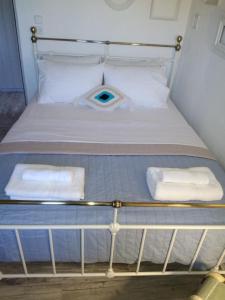 a bed with two towels on top of it at Persephone in Ioulis