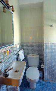 Łazienka z białą toaletą i umywalką w obiekcie Hostal Rocamar w Almuñécar