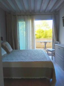 a bedroom with a bed and a window with a table at Au Fil de l'Eau in Mouroux