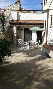 a patio with a table and chairs and an umbrella at Apartment Tijano in Krnica