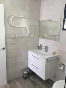 Baño blanco con lavabo y espejo en Your place to relax in Mijas Costa, en Mijas