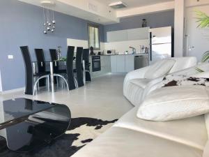 ein Wohnzimmer mit einem weißen Sofa und einem Tisch in der Unterkunft Apartment "Style City" With Sea View in Bat Yam