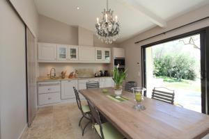 戈尔德Mas De Gordes的厨房配有带椅子的木桌和吊灯。