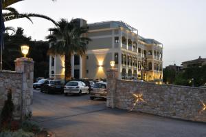 un grand bâtiment avec des voitures garées dans un parking dans l'établissement Corfu Mare Hotel -Adults only, à Corfou