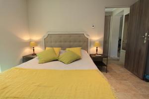 ゴルドにあるMas De Gordesのベッドルーム1室(大きな黄色のベッド1台、黄色の枕2つ付)