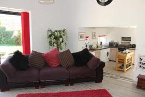 uma sala de estar com um sofá e uma cozinha em gite les rouets em Hanc