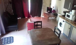 a kitchen with a table and chairs and a microwave at La mare au Loup in Vitré