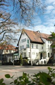 a white building with a red roof on a street at Pensjonat Irena in Sopot