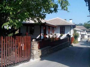 a white house with a fence in front of it at Дядовата къща in Tryavna