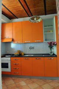 a kitchen with orange cabinets and a stove at Villa Eleanto in Cefalù
