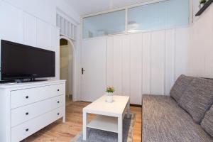 a living room with a couch and a tv at Apartments Pavic in Malinska