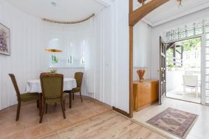 a dining room with a white table and chairs at Apartments Pavic in Malinska