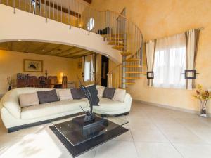 ein Wohnzimmer mit einem Sofa und einer Wendeltreppe in der Unterkunft Luxury holiday home with private pool in Rodilhan