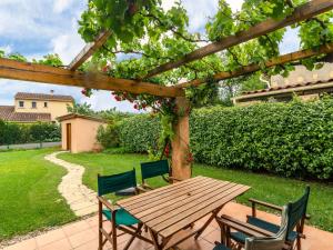 a wooden table and chairs in a yard at Colourful Holiday Home in Noves with Swimming Pool in Noves