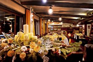 un comedor con una mesa larga con flores y velas en Hotel Chalet Il Capricorno, en Sauze dʼOulx