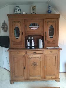a large wooden cabinet with a microwave on top at B&B De Koraal in Emmen