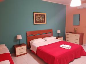 a bedroom with a large bed with a red blanket at The Artists in Acireale