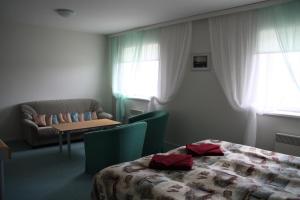 a hotel room with a bed and a couch and a table at Heltermaa Hostel in Heltermaa