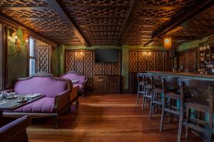 a bar with pink couches and a table and chairs at Skeffington Arms Hotel in Galway