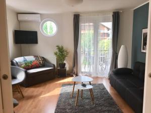 a living room with a couch and a table at Lake Apartment in Hévíz