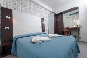 a bedroom with two towels on a blue bed at Bed & Breakfast Armonie Romane in Rome