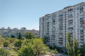 un gran edificio de apartamentos en una ciudad con árboles en ARTAL Apartment on Obolonskyi Avenue 16a, en Kiev