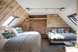 a bedroom with two beds and a brick wall at One Broad Street in Brighton & Hove