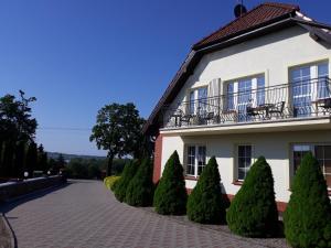 a white building with a balcony and some trees at Pokoje Salent in Mrągowo +32 photos