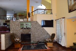 a living room with a fireplace and a staircase at Adies Garden Suites in Nairobi