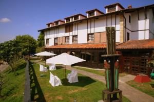 ein Gebäude mit Tischen und Sonnenschirmen davor in der Unterkunft Hotel Colegiata in Santillana del Mar