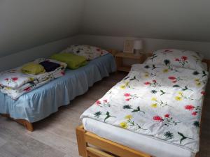 two twin beds in a room with flowers at Domek w Dolinie Teczy in Dębina