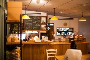 een vrouw die aan een balie in een restaurant zit bij Blue Sky in Ashkelon in Ashkelon