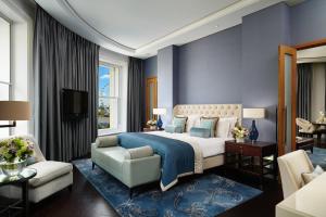 um quarto com uma cama king-size e uma sala de estar em Corinthia London em Londres