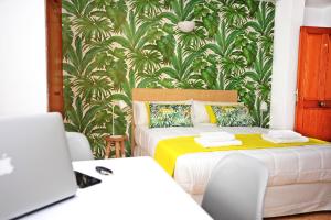 
a room with a bed, desk, chair and a laptop at Los Escondidos Ibiza in Playa d'en Bossa

