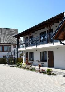 a white building with a balcony and a courtyard at Morza Szum in Dziwnów