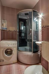 a bathroom with a shower and a washing machine at Residence 30 in Bucharest