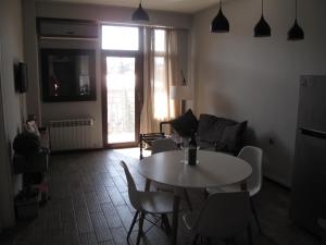 a living room with a table and chairs and a window at Great view apartment near Piazza Batumi in Batumi