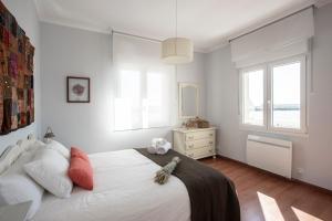 Un dormitorio con una gran cama blanca y una ventana en Vivienda O Pombal, en Cambados