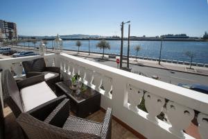 a balcony with chairs and a view of a river at Vivienda O Pombal in Cambados