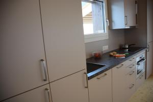 uma cozinha com armários brancos e uma janela em Chalet Nr. 50 em Flühli