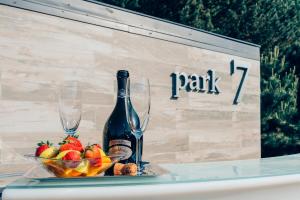 a bottle of wine and a bowl of fruit on a table at Park7 in Tiszafüred
