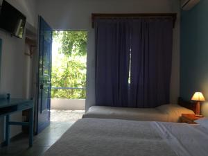 a bedroom with a bed and a window and a desk at Ikion Studios in Steni Vala Alonissos