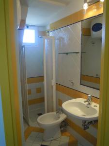 a bathroom with a sink and a toilet and a shower at Appartamenti Doria II in Porto Garibaldi