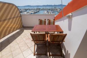 einen Tisch und zwei Stühle auf einem Balkon mit Hafen in der Unterkunft Apartments Onorina in Zadar