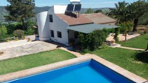 una villa con piscina frente a una casa en El Campito - CASA RURAL, en Ronda