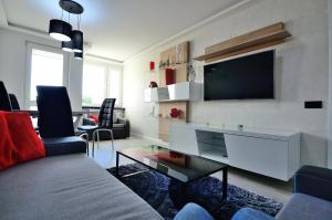 ソポトにあるVictus Apartamenty, Apartament Teslaのリビングルーム(壁に薄型テレビ付)