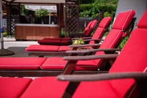 a row of red chairs sitting on a patio at Penzion Šterk in Most na Soči