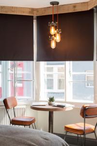 a bedroom with black blackout blinds and a table and chairs at One Broad Street in Brighton & Hove