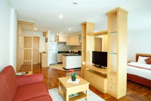 sala de estar con cama, sofá y cocina en Chaidee Mansion, en Bangkok