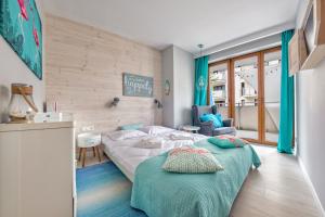 a bedroom with a bed and a chair in it at Apartamenty Sun & Snow Baltic Park Stegna in Stegna